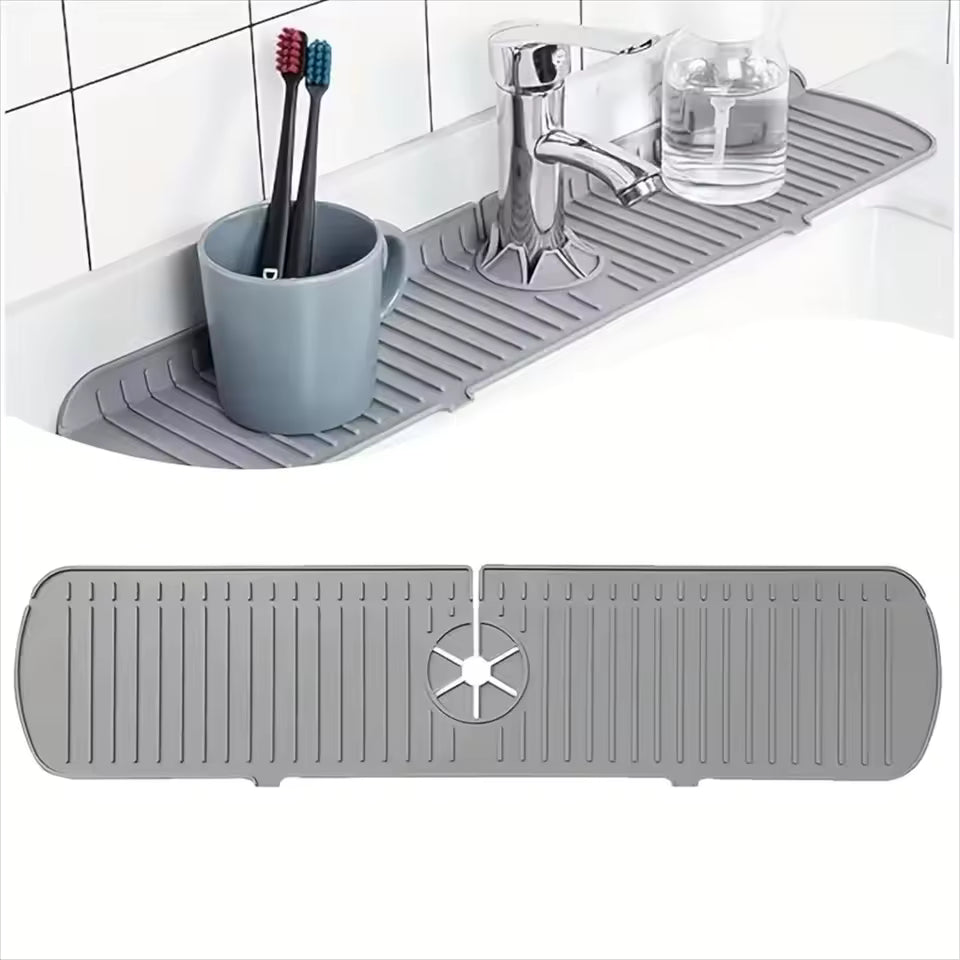 Gray rubber mat on a bathroom counter with a cup, toothbrushes, and glass of water.
