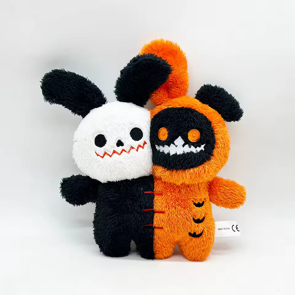 Two plush toys, one black and white and one orange with a face, on a white background.