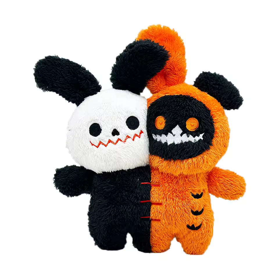 Two plush toys, one black and white and the other orange and black, on a white background.
