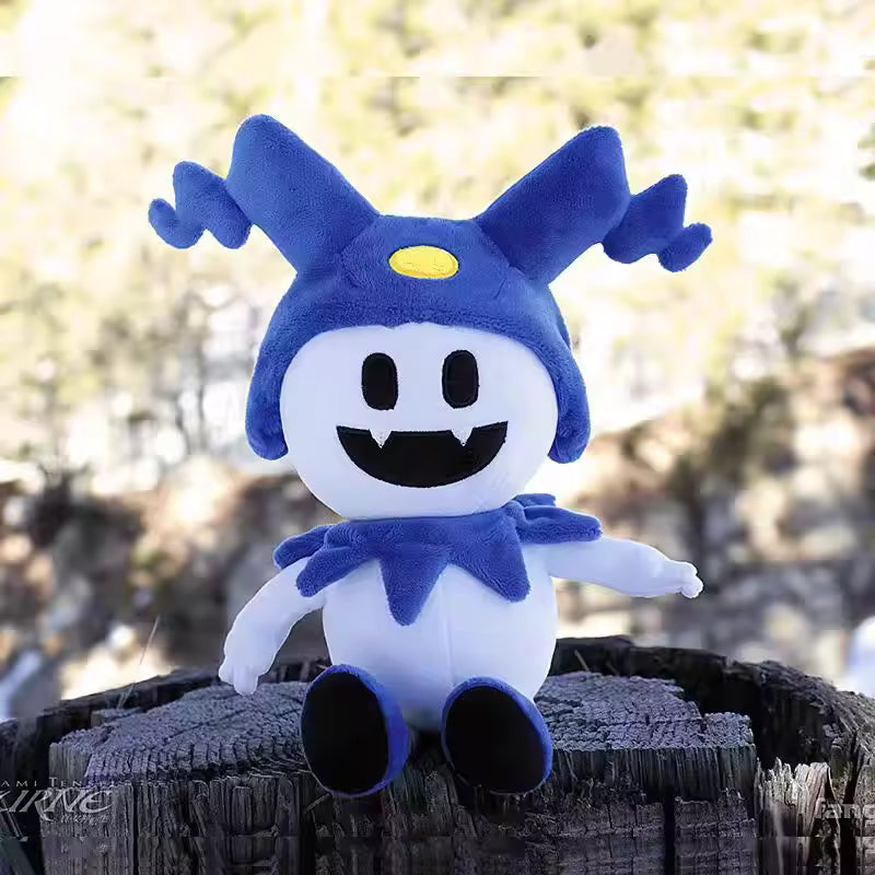 Blue and white plush toy with a yellow circle on a wooden log