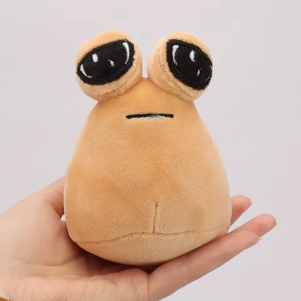 Plush toy resembling a cartoonish brown creature with large black eyes held in a hand against a light gray background.