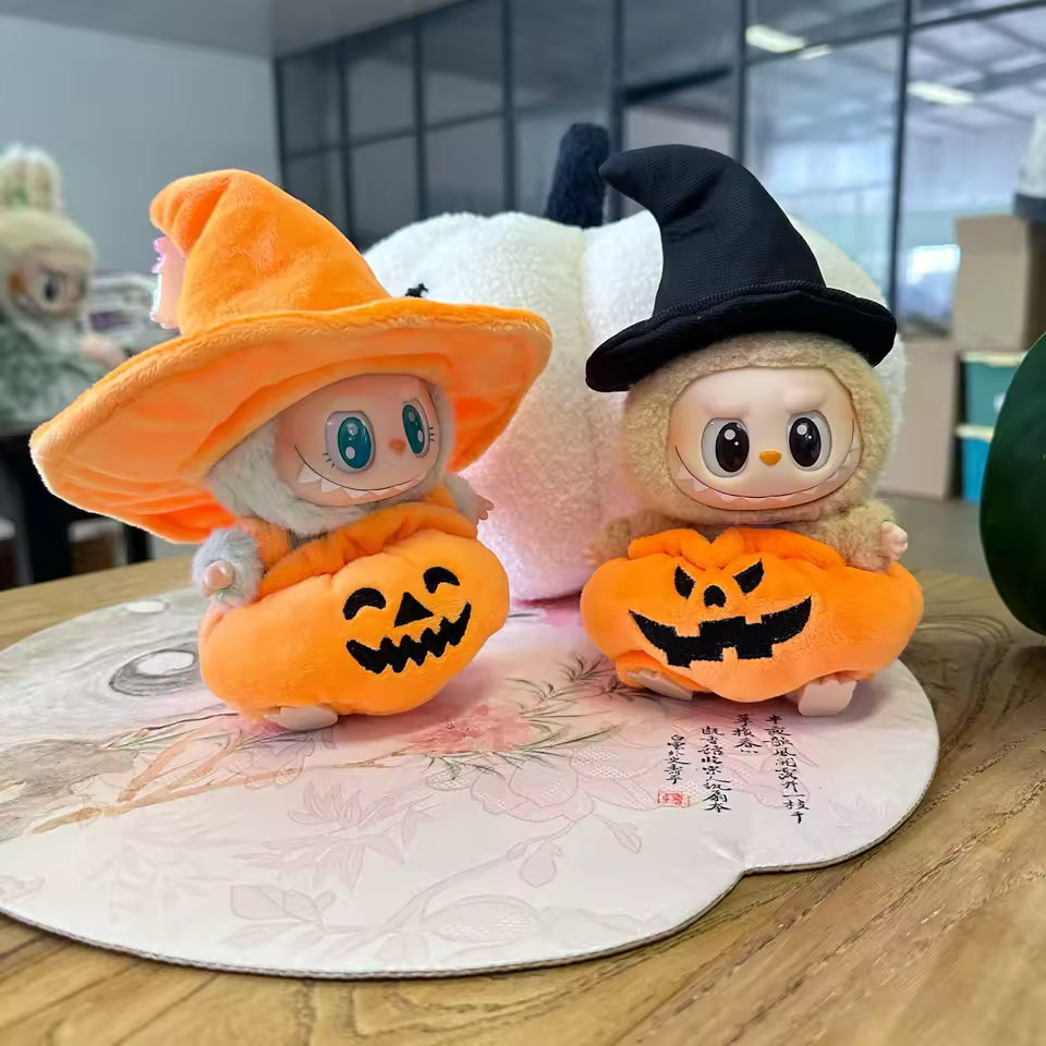 Two plush toys with Halloween-themed costumes on a decorative mat.